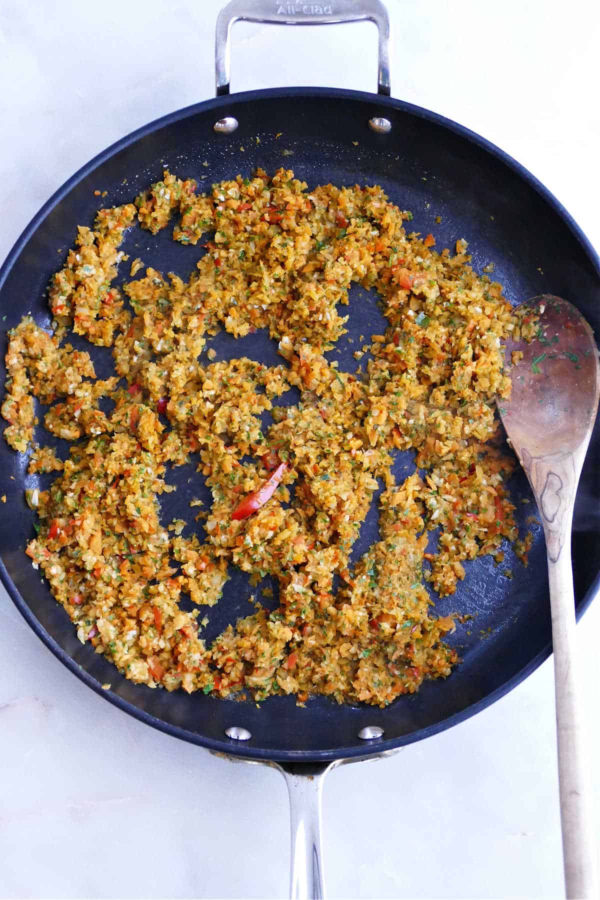 vegetables and walnuts cooking with seasonings and oil in a nonstick skillet