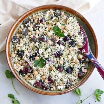 quinoa grape salad with herbs in a serving bowl with a spoon