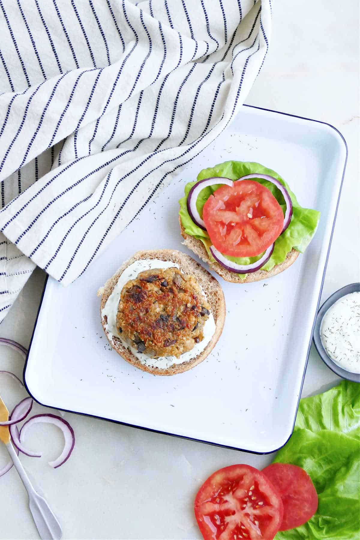 quinoa mushroom burger on a bun next to bun with lettuce and tomato