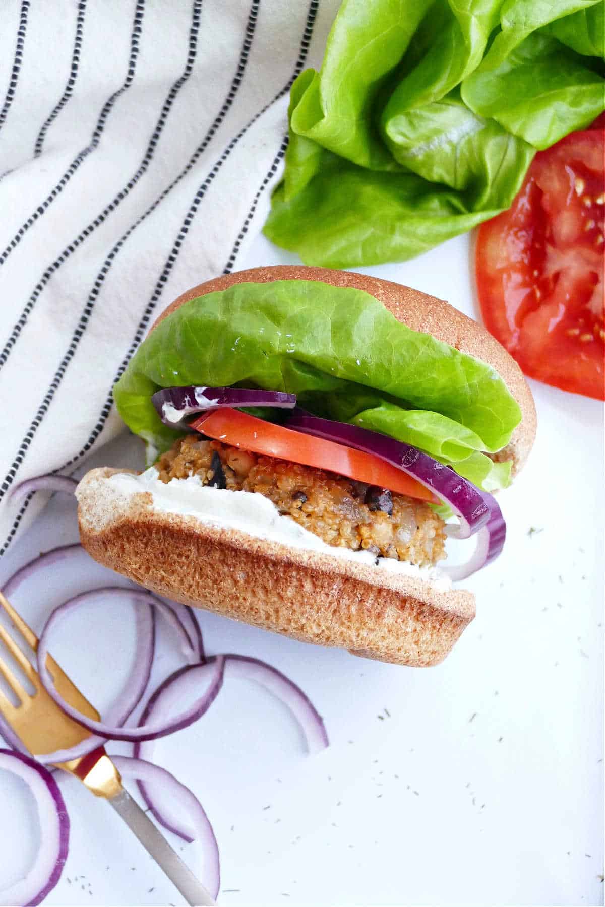 quinoa mushroom burger topped with lettuce, onion, and tomato on a bun