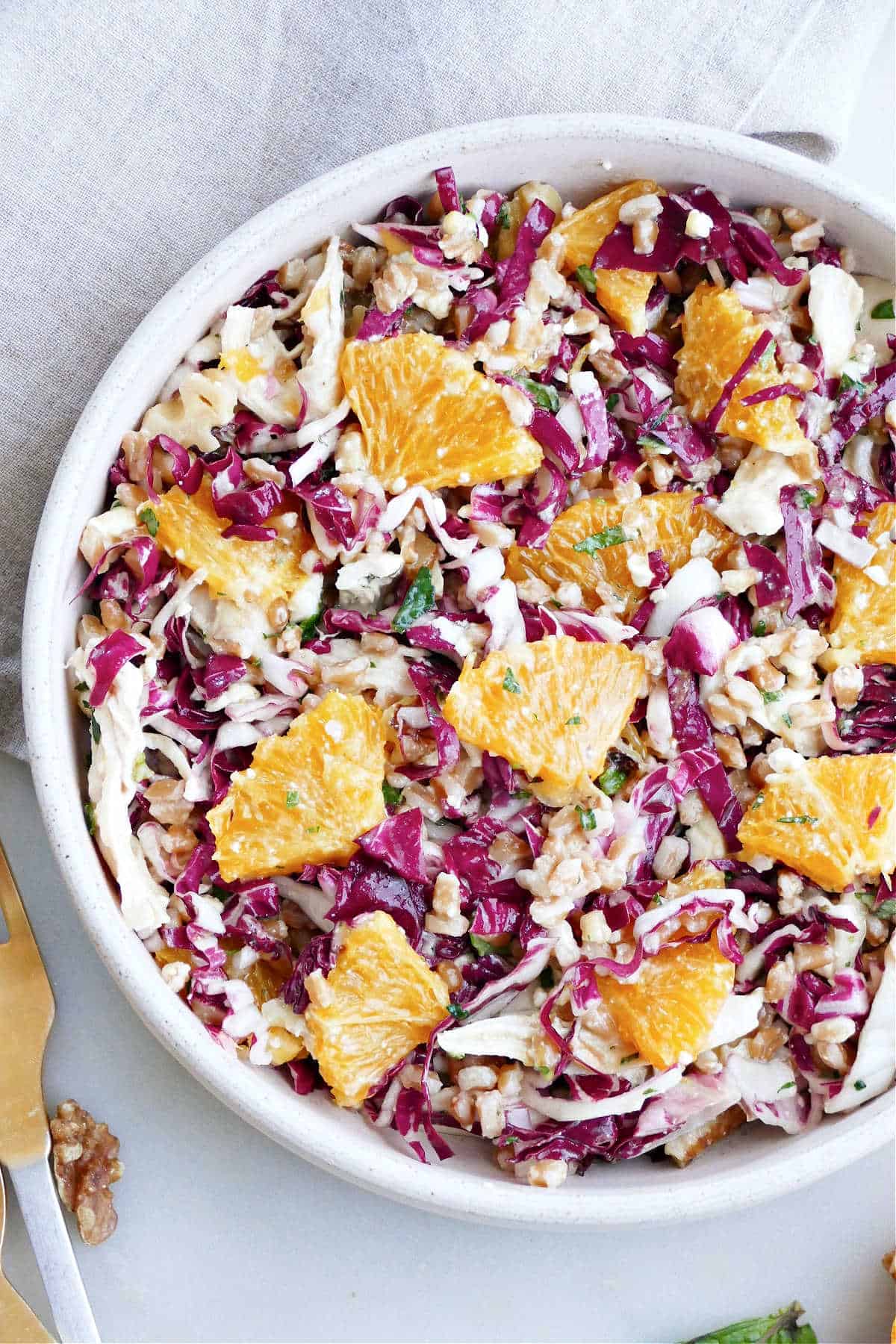 radicchio, citrus, farro, chicken, herbs, and feta salad in a serving bowl