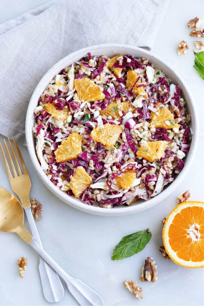 shredded radicchio salad with citrus, chicken, and farro in a serving bowl