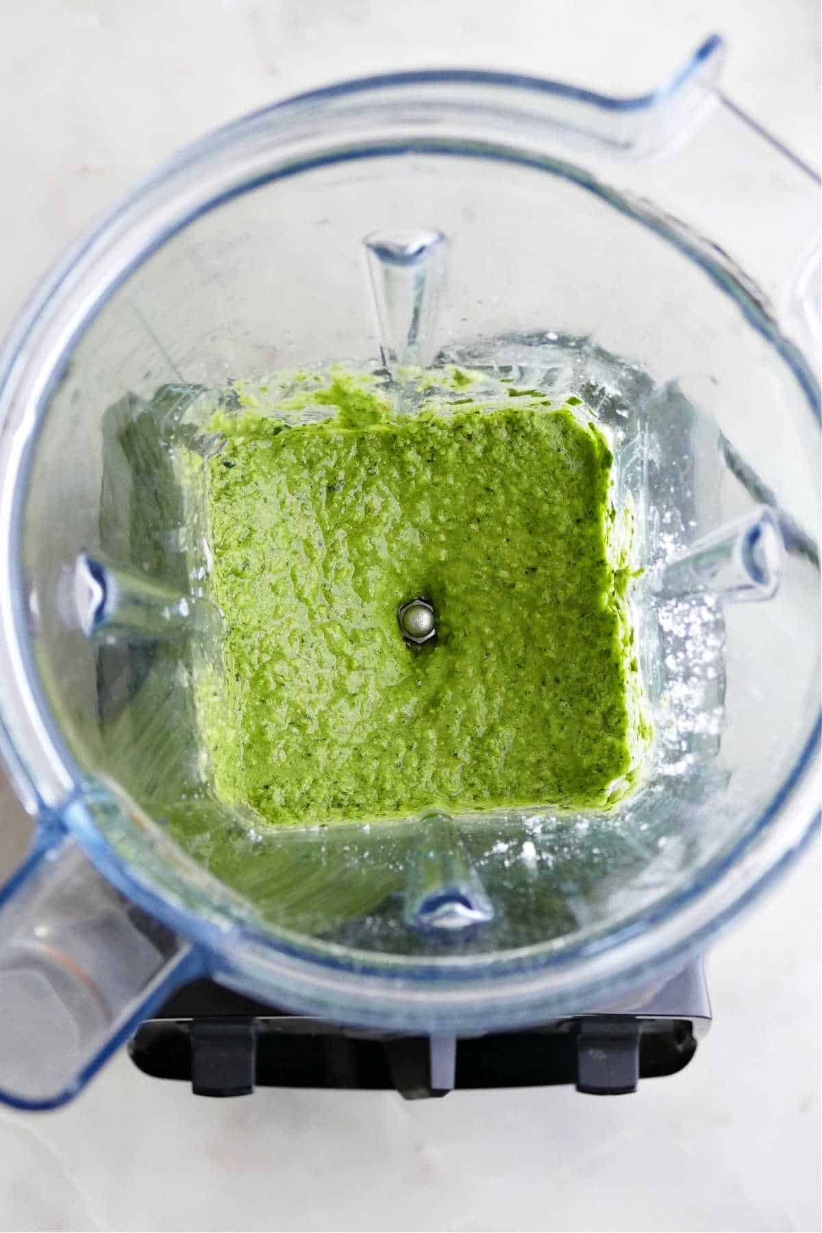 fresh basil pesto being blended in a Vitamix blender on top of a counter