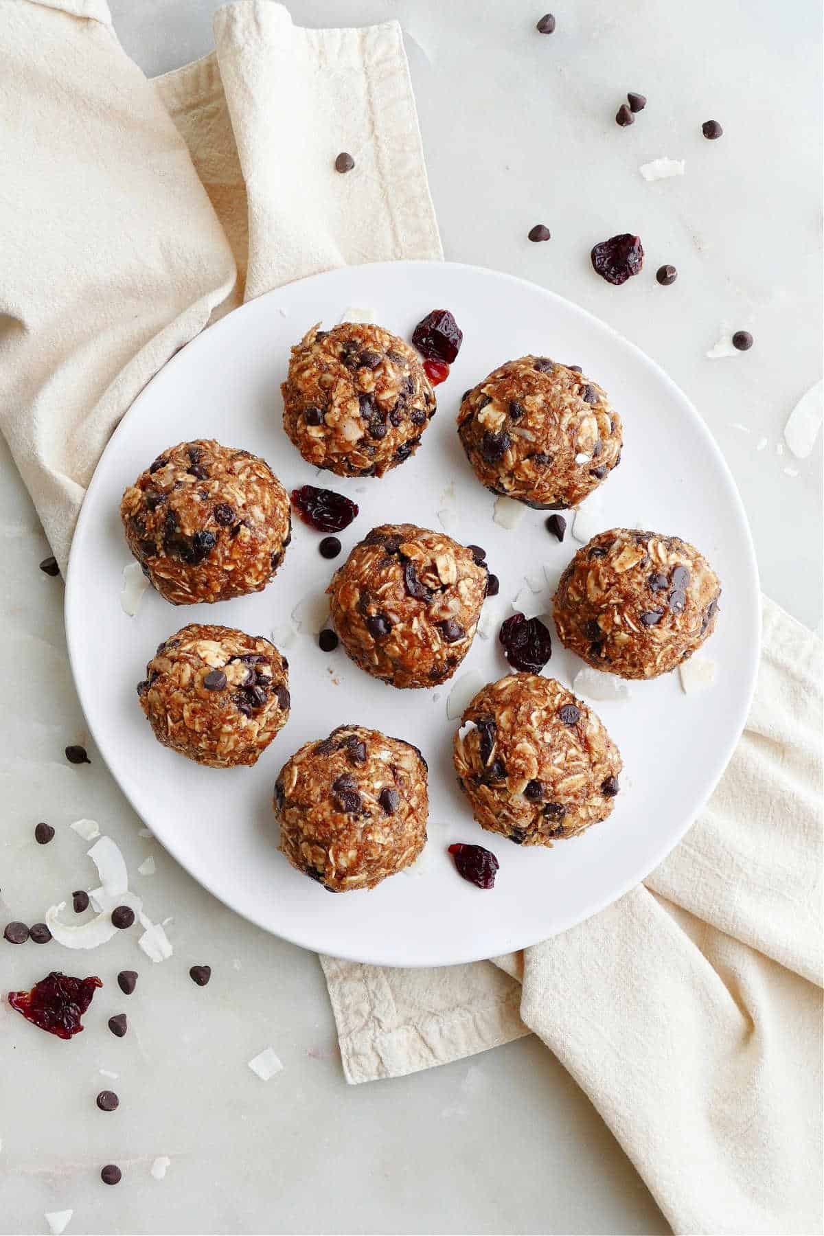 eight almond butter energy balls with cherries on a serving plate on a napkin