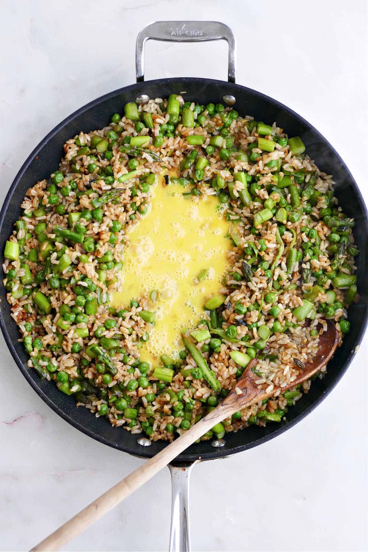 asparagus fried rice and scrambled eggs cooking in a nonstick skillet