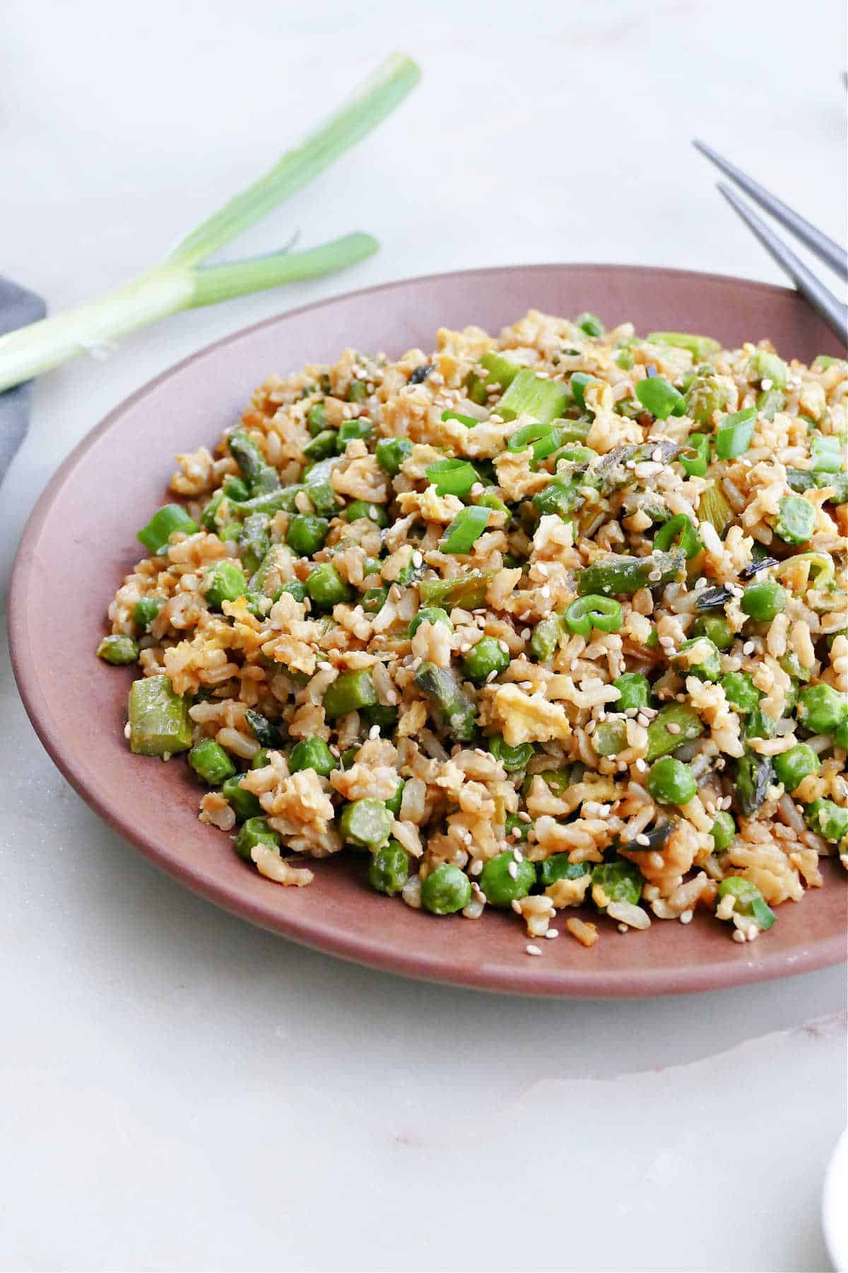 asparagus fried rice with peas on a serving plate on a counter