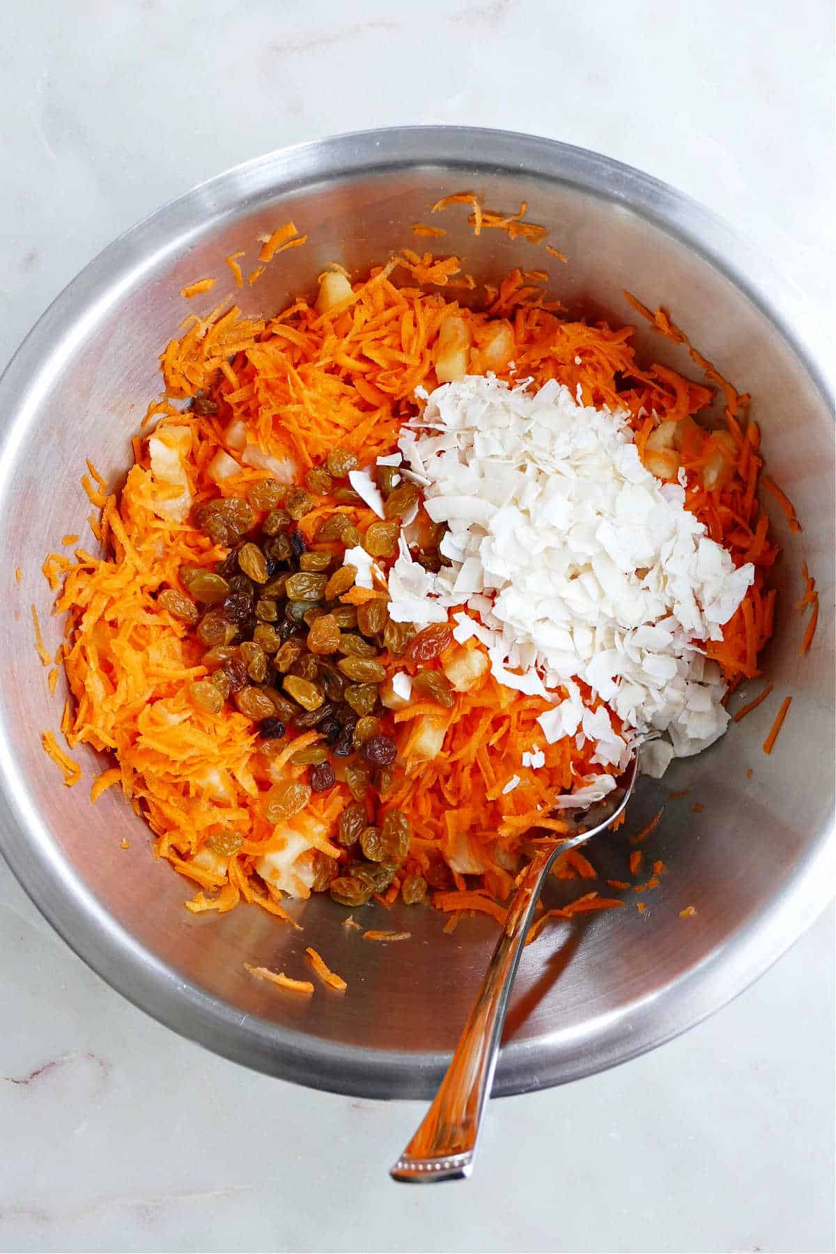 dry ingredients for carrot raisin salad with pineapple in a mixing bowl