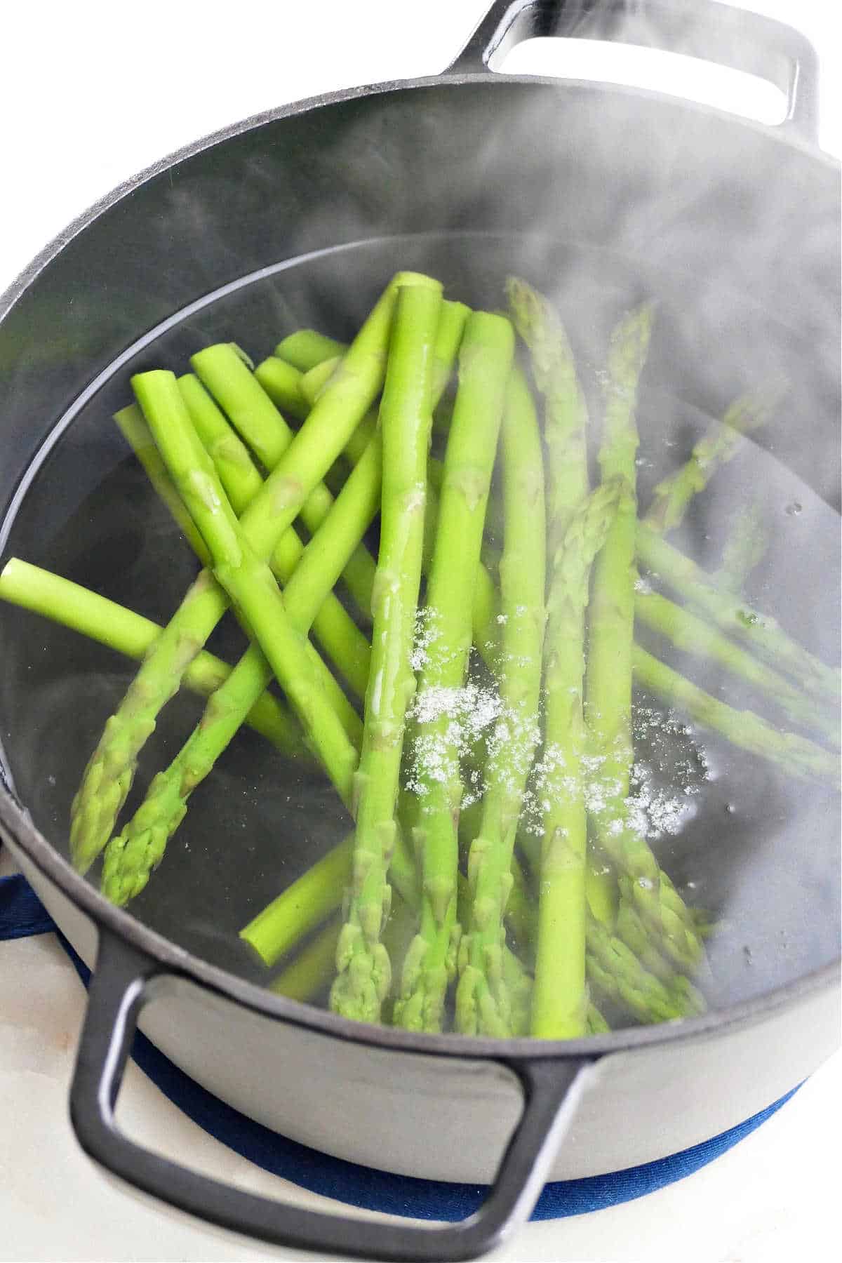 asparagus spears being blanched in a pot of boiling water