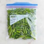 frozen sliced asparagus in a freezer bag labeled with asparagus and date