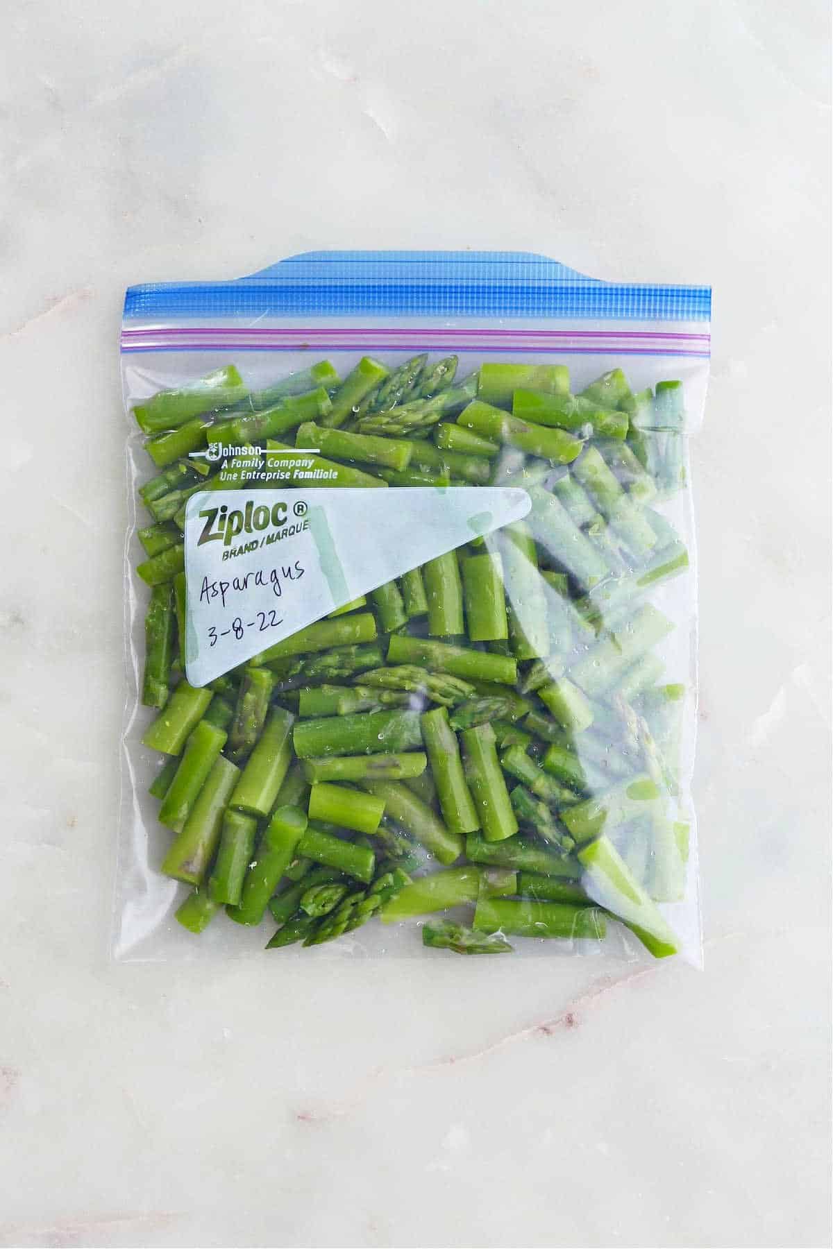 frozen sliced asparagus in a freezer bag labeled with asparagus and date
