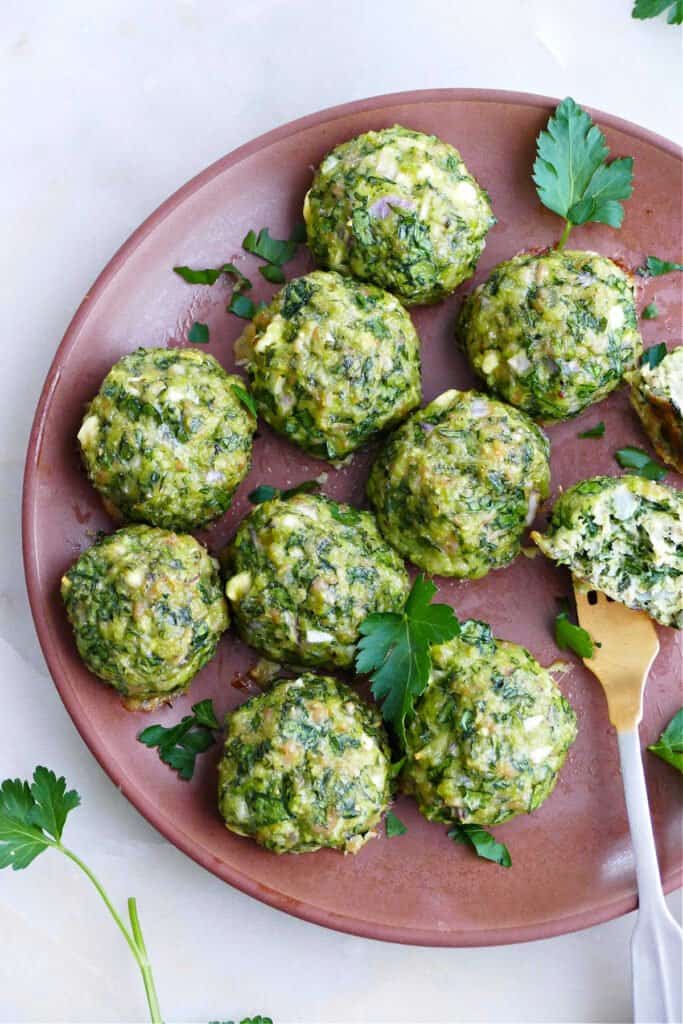 spinach chicken meatballs on a serving plate sprinkled with parsley