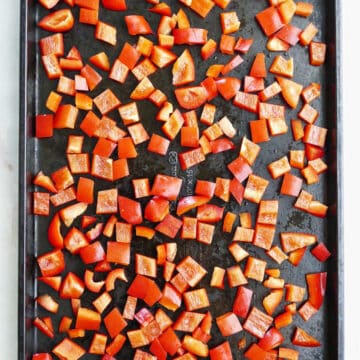 diced bell peppers spread out on a baking sheet before being frozen