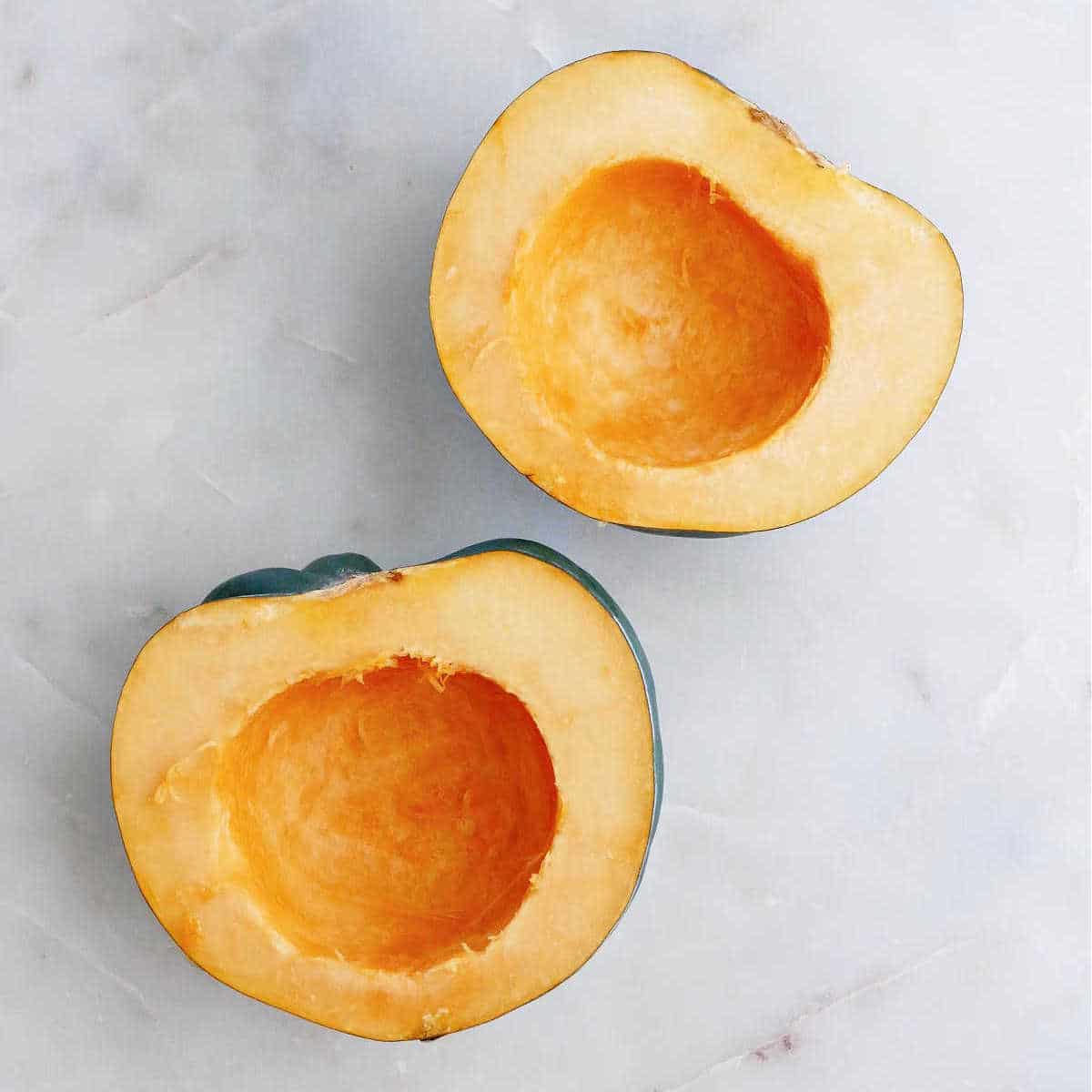 halved and deseeded acorn squash halves on a counter