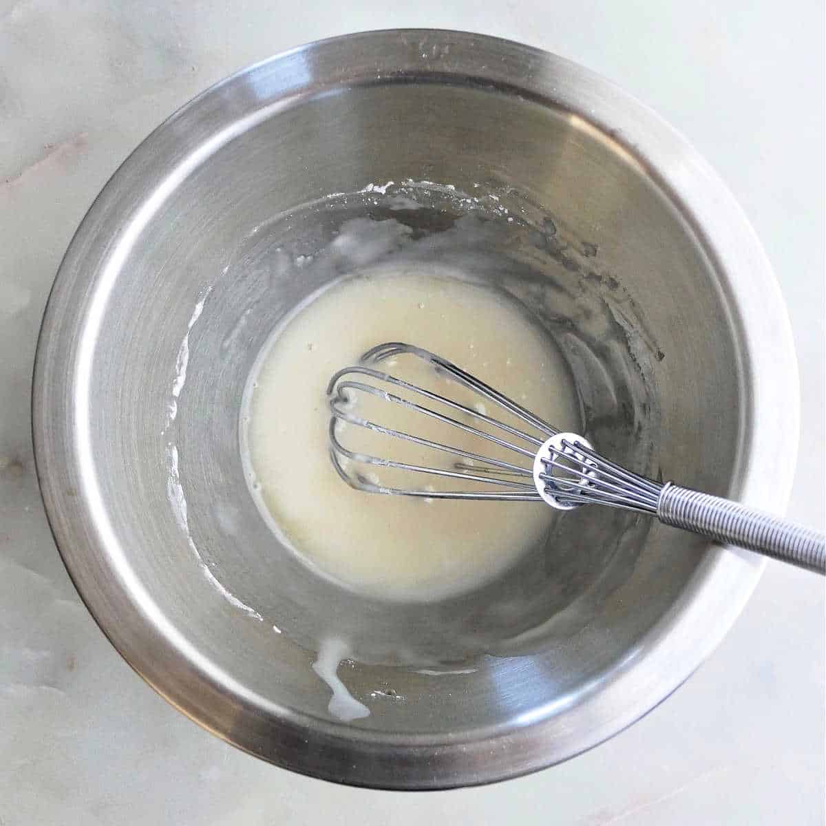 apple cider and powdered sugar whisked into a glaze in a bowl