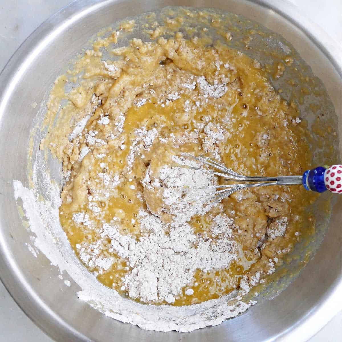 wet and dry ingredients for acorn squash bread mixed together in a bowl