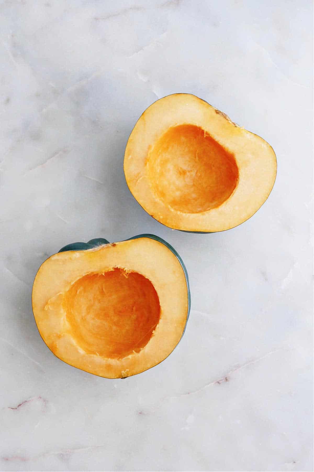 acorn squash halves with seeds removed on a counter