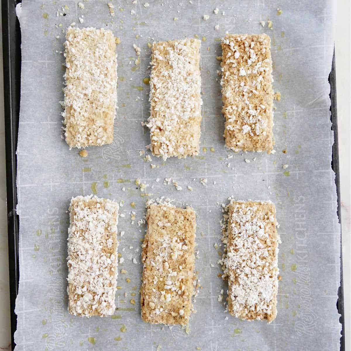 three pieces of panko crusted tofu on a baking sheet with parchment