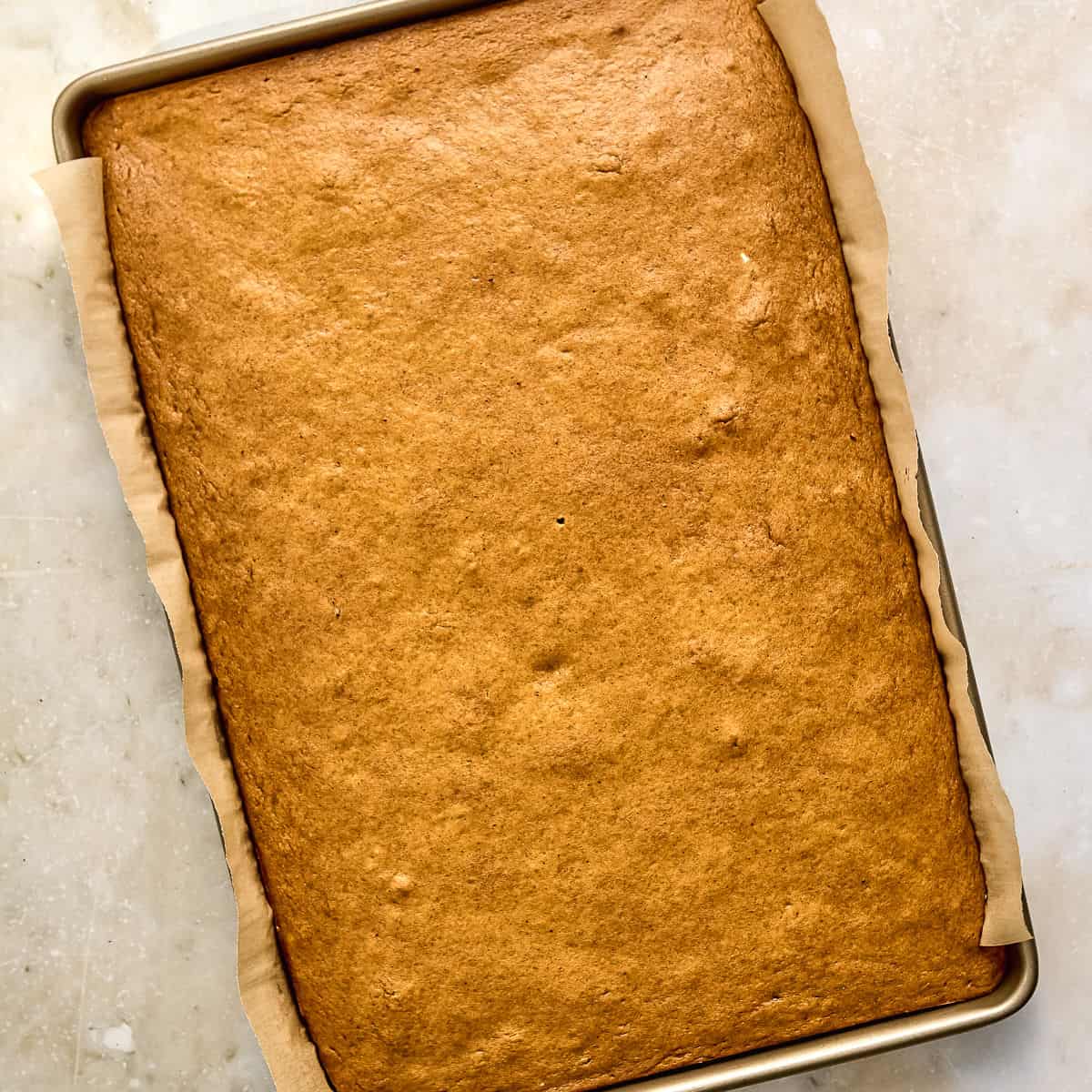Pumpkin bars on a half sheet pan after coming out of the oven.