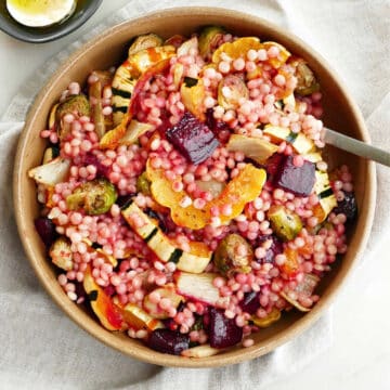 fall vegetables and couscous in a serving bowl with a spoon