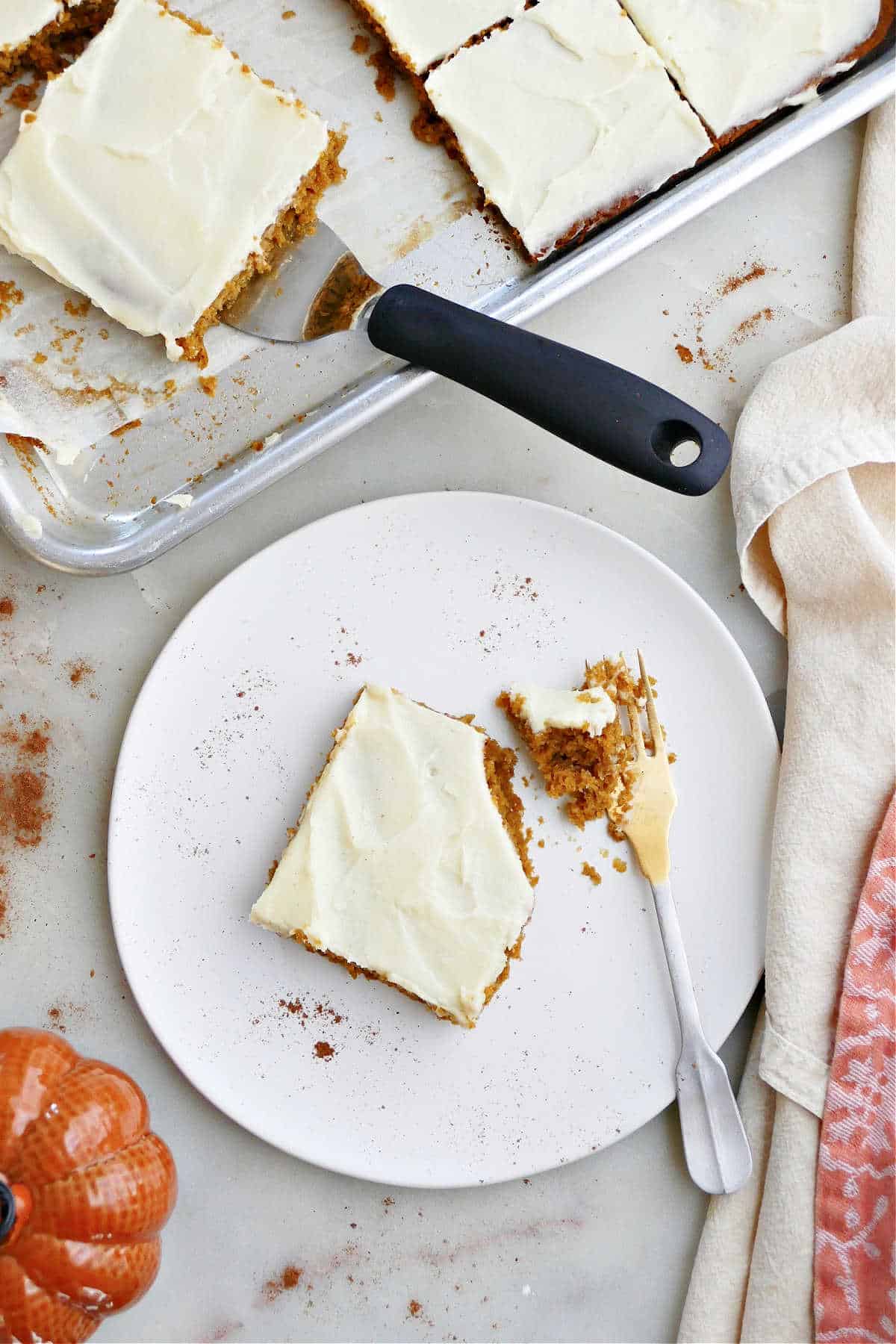 pumpkin bar with cream cheese frosting on a plate with a fork