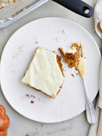 pumpkin bar with cream cheese frosting on a plate with a fork