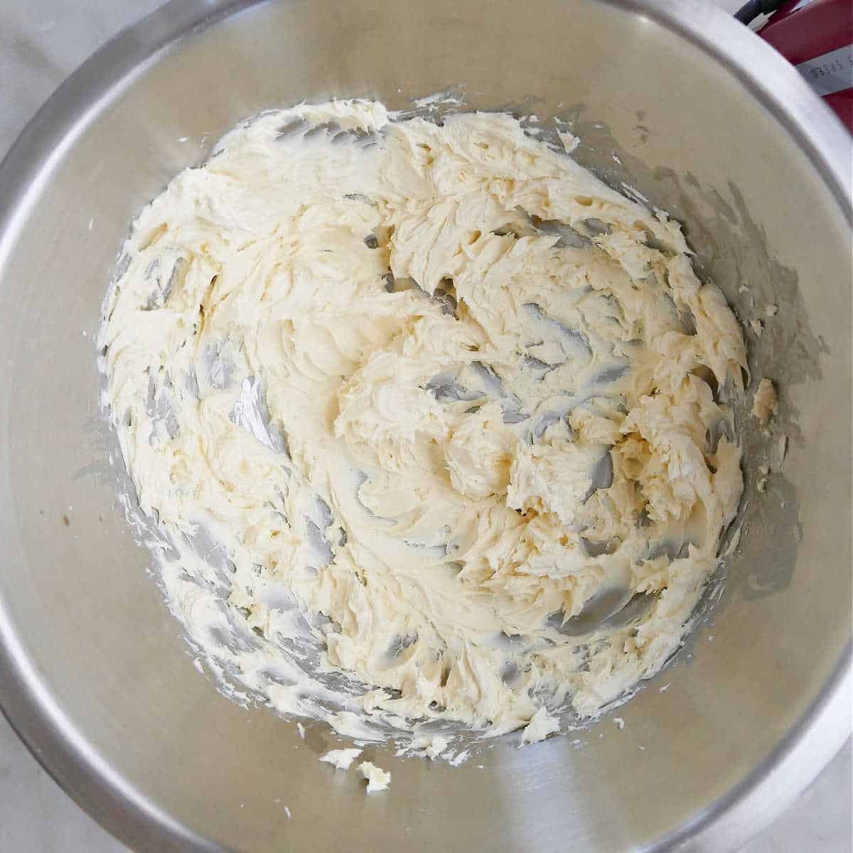 ingredients for cream cheese frosting whipped in mixing bowl