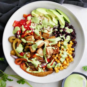 tofu burrito bowl with tahini dressing on a counter next to a napkin