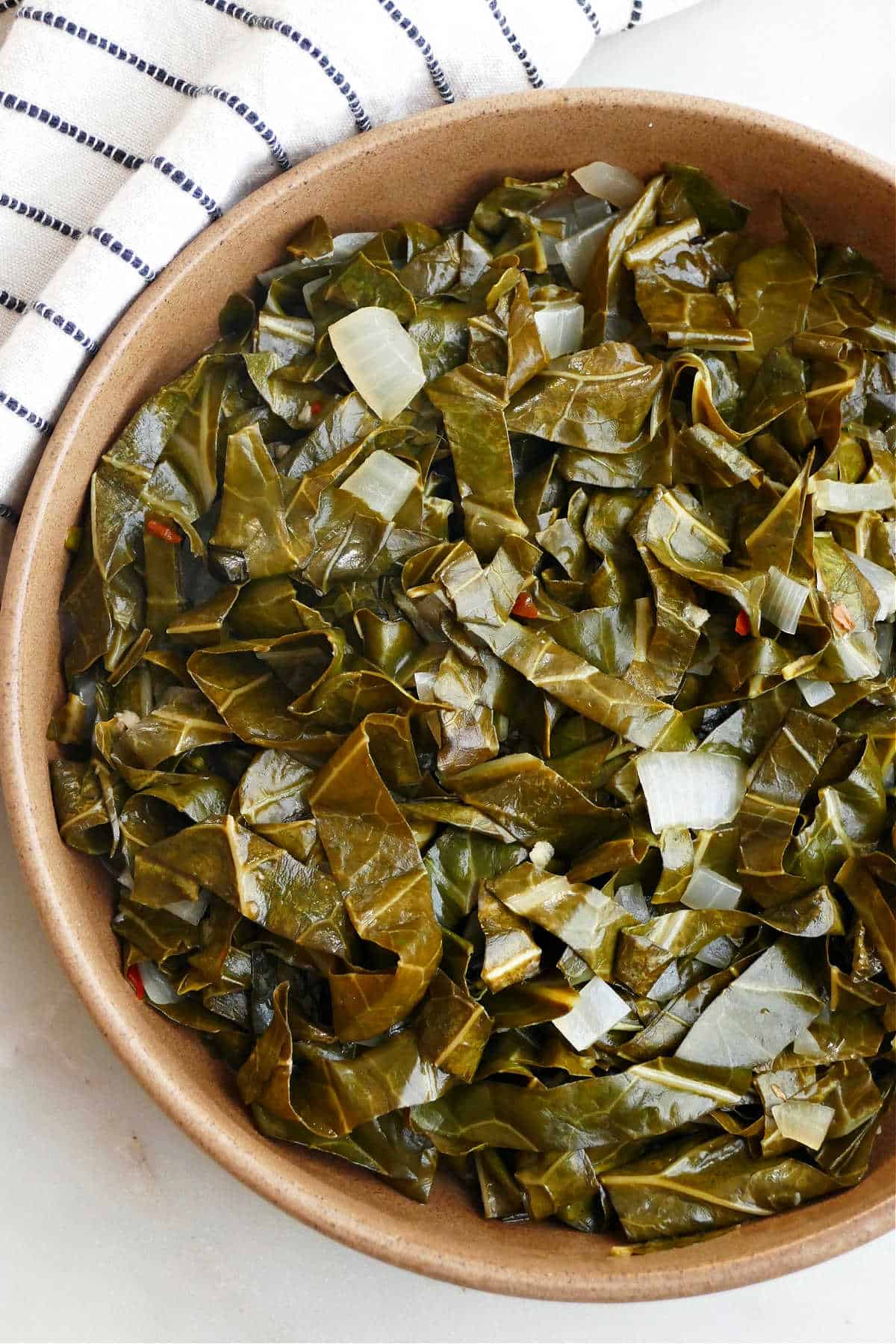 collard greens cooked in a crock pot in a serving bowl on a counter