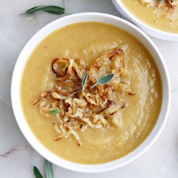 swede and potato soup in a bowl topped with crispy onions