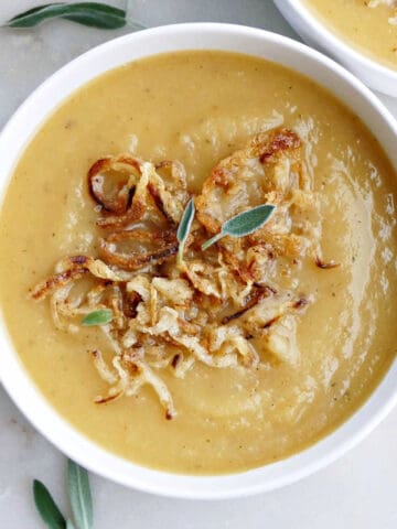 swede and potato soup in a bowl topped with crispy onions