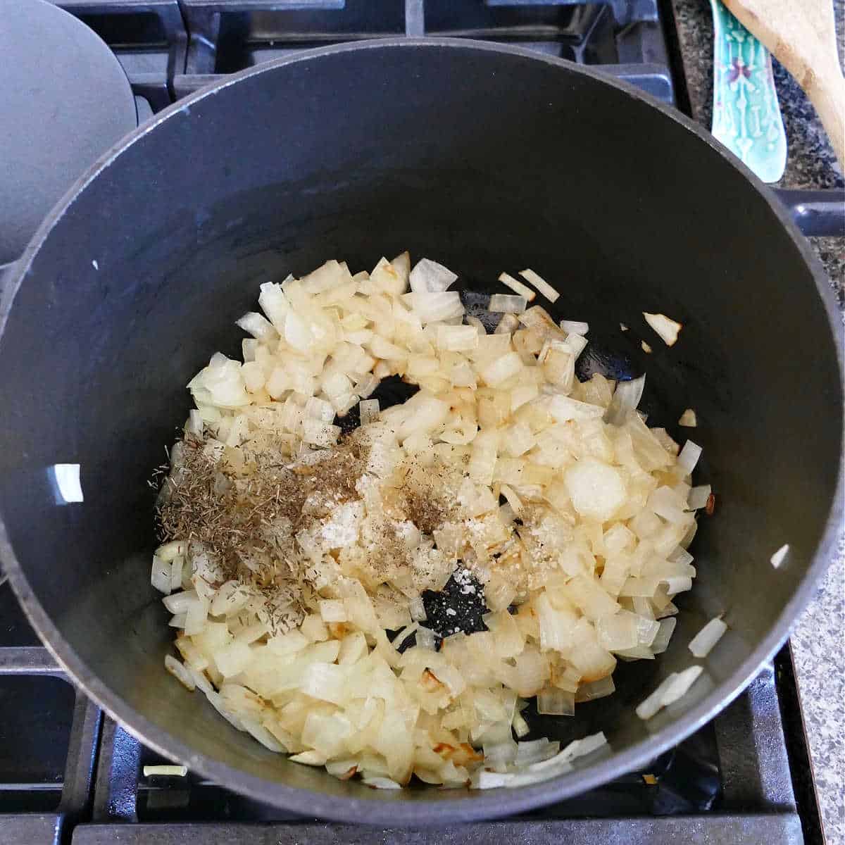diced onions cooking in olive oil in a soup pot with seasonings