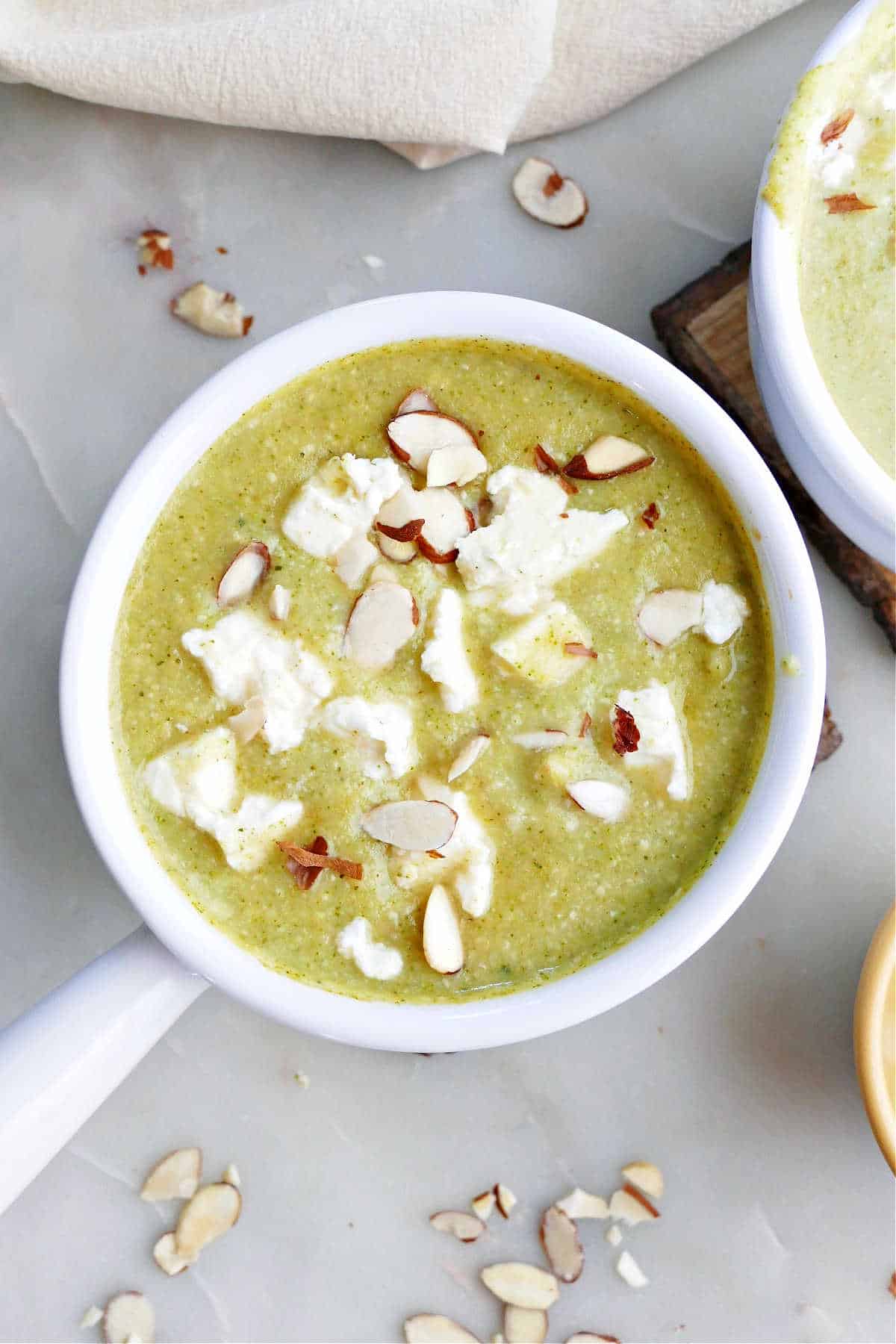 broccoli almond soup with feta in a soup crock on a counter