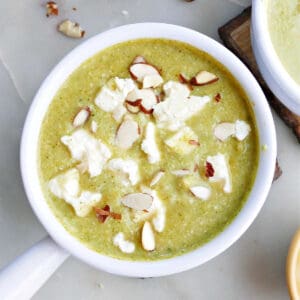 broccoli almond soup with feta in a soup crock on a counter