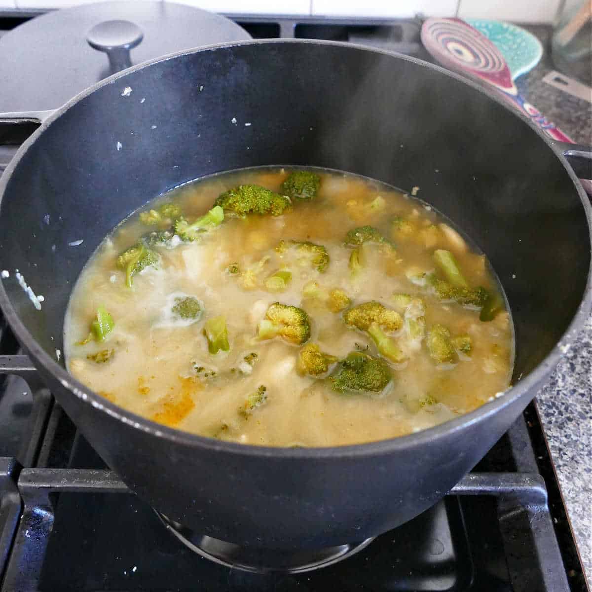 broccoli soup ingredients and almond milk in a soup pot