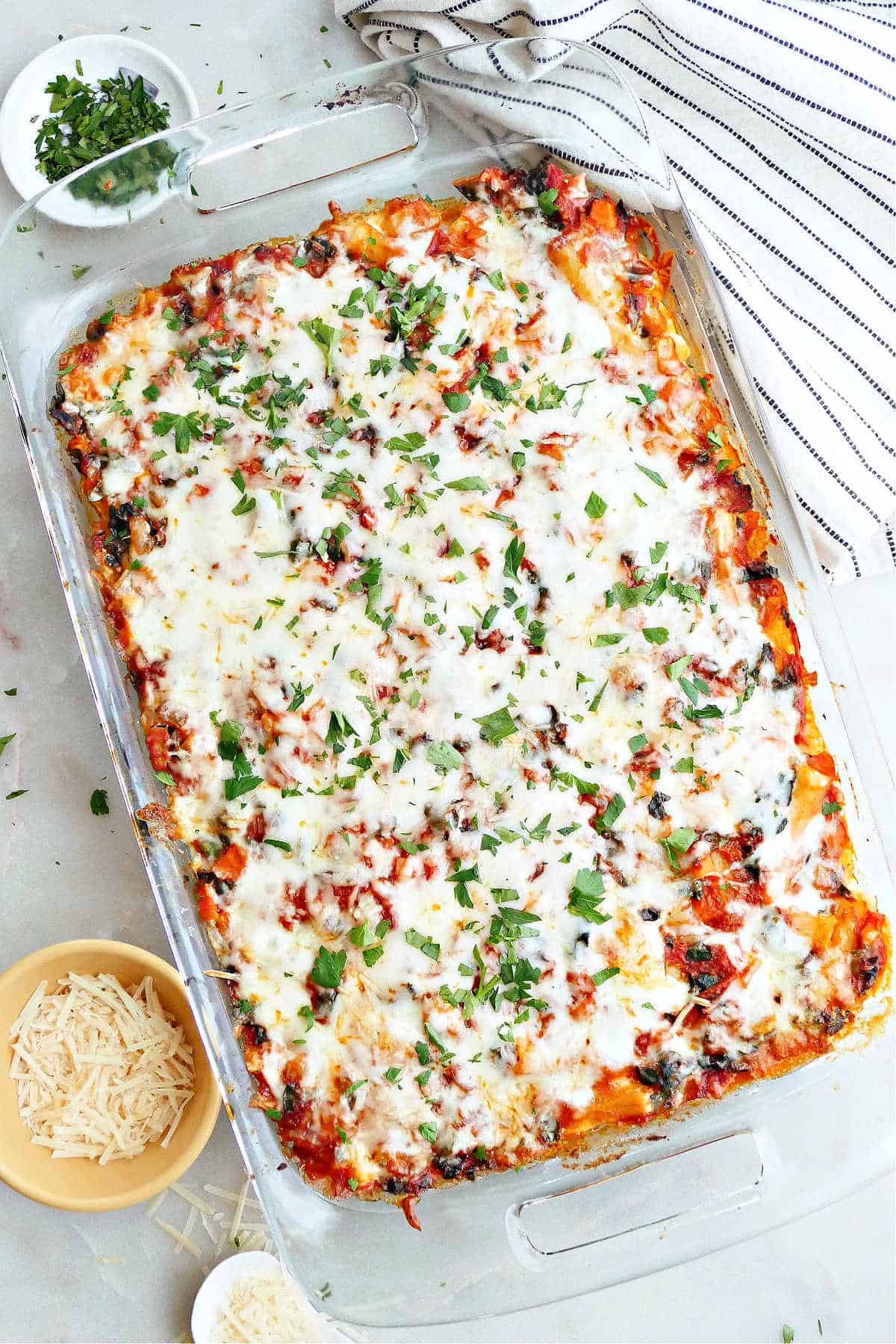 meatless baked ziti topped with fresh parsley in a baking dish on a counter