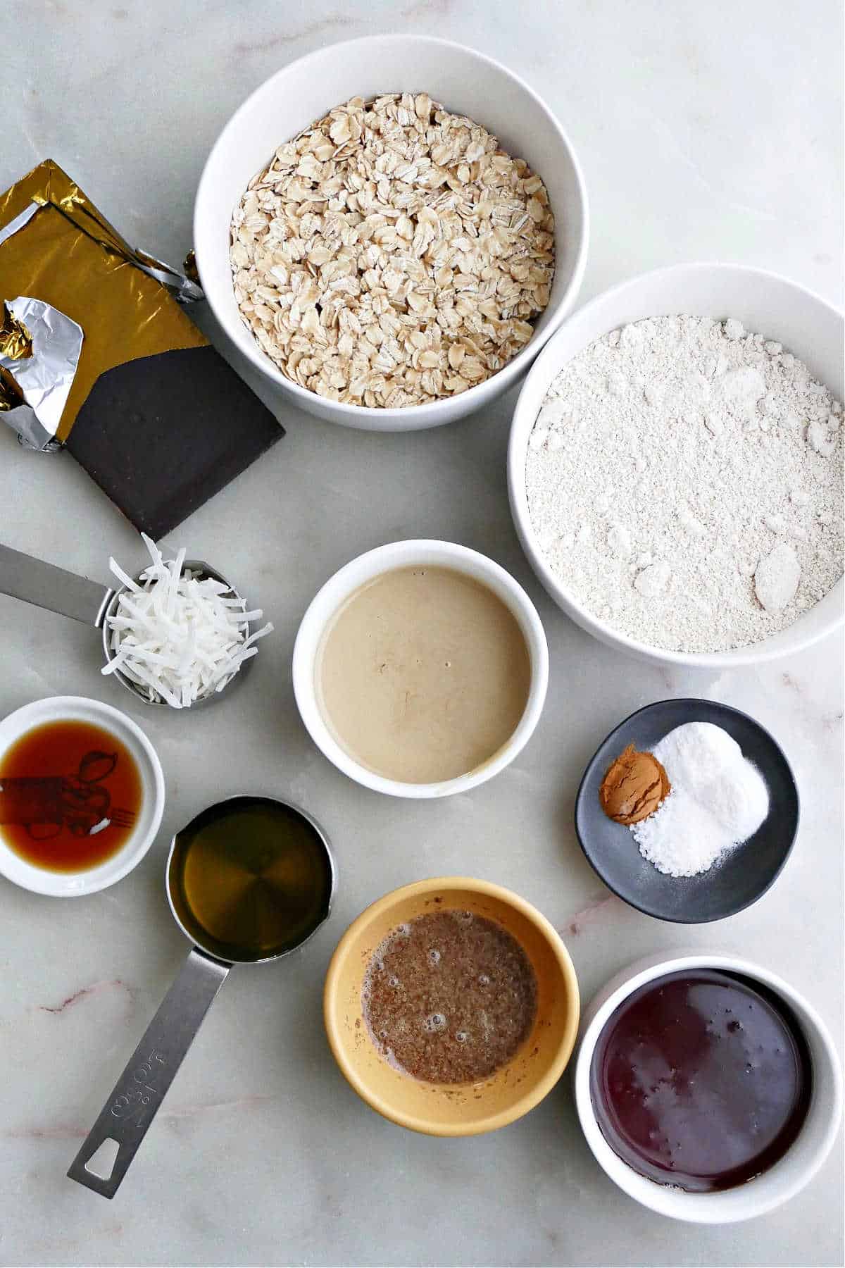 dry and wet ingredients for tahini oatmeal chocolate chunk cookies on a counter