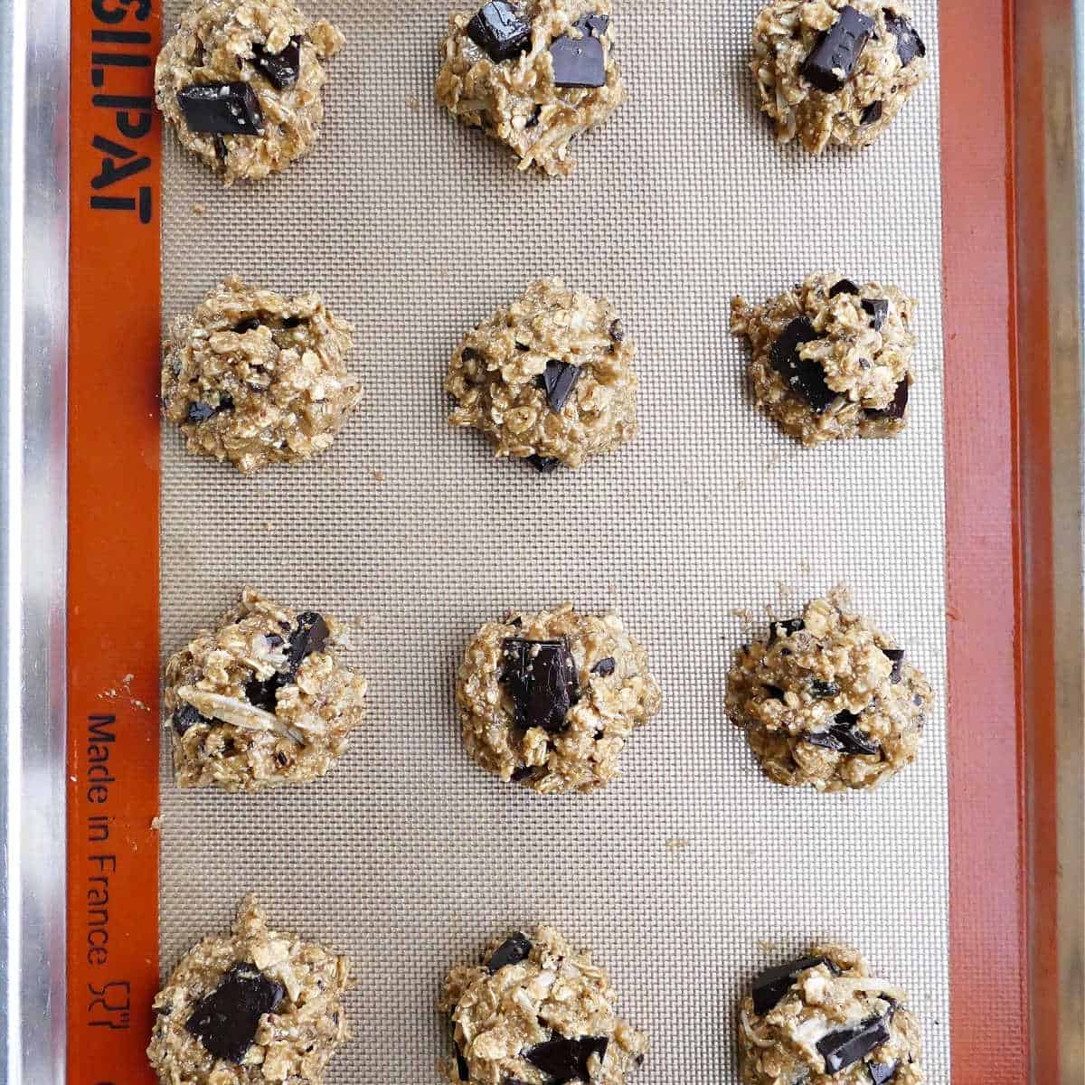 tahini oatmeal cookies on a lined baking sheet before going into oven