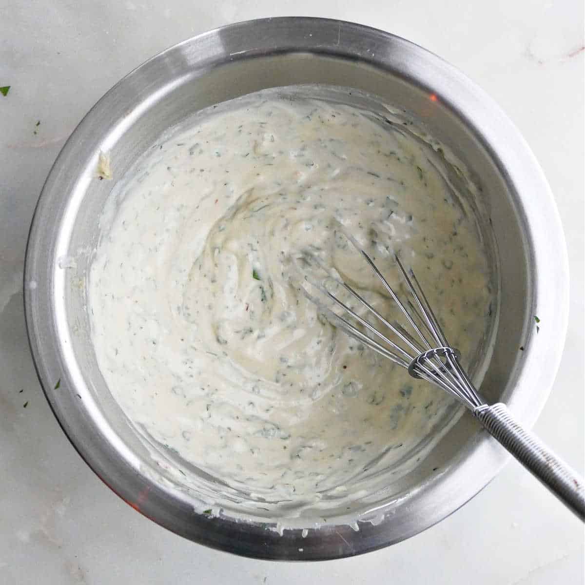 lemon tahini pasta sauce being whisked in a small bowl