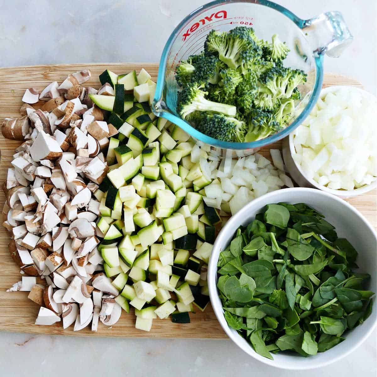 vegetables for white lasagna cut up on a cutting board