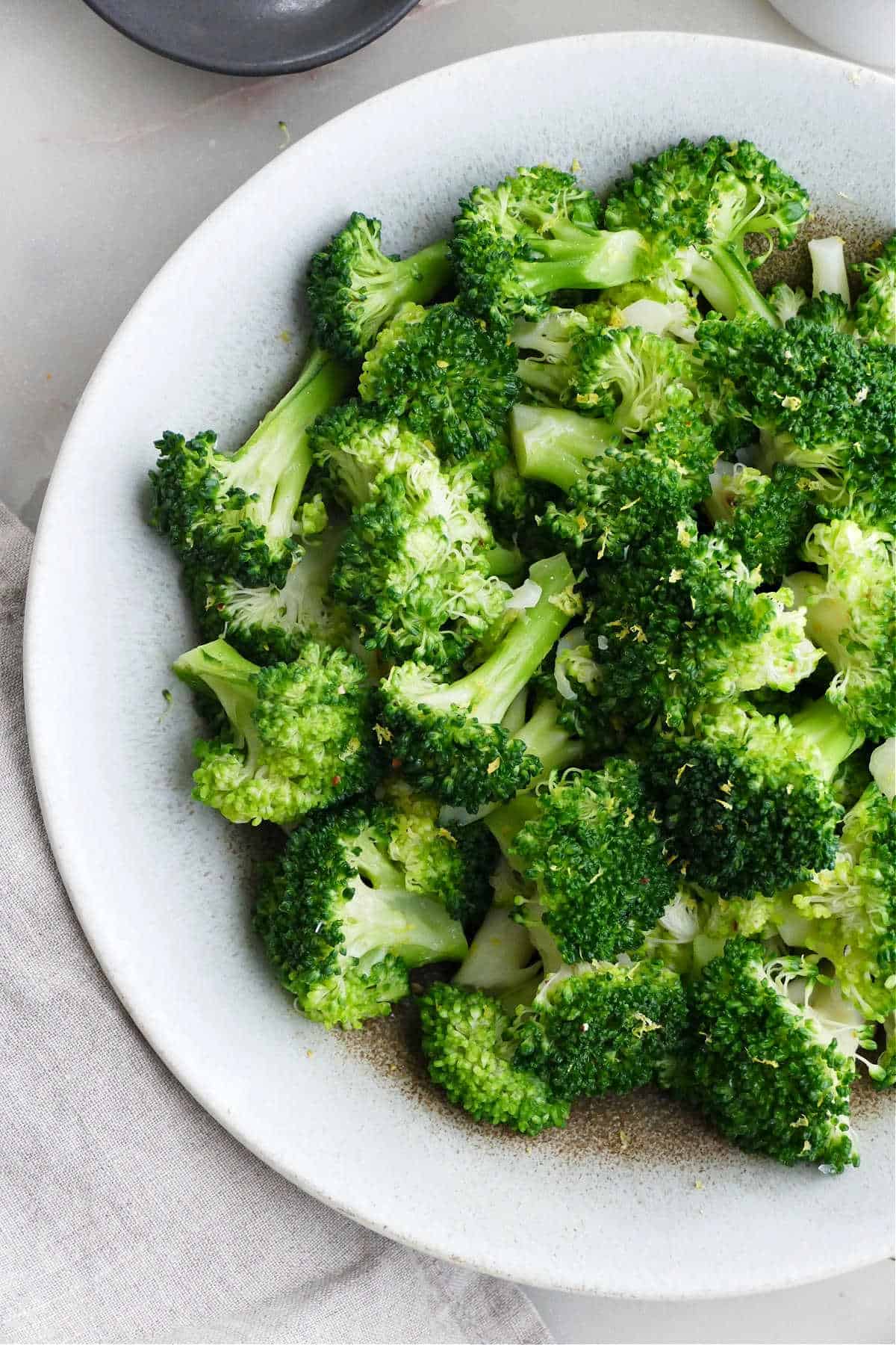 cooked broccoli with seasonings in a serving bowl