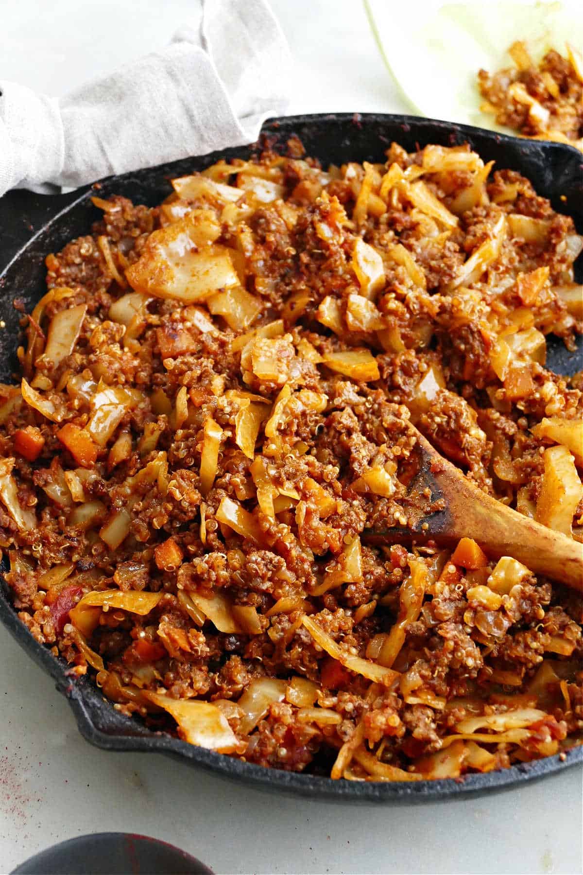 cabbage roll cast iron skillet with a spoon on a counter