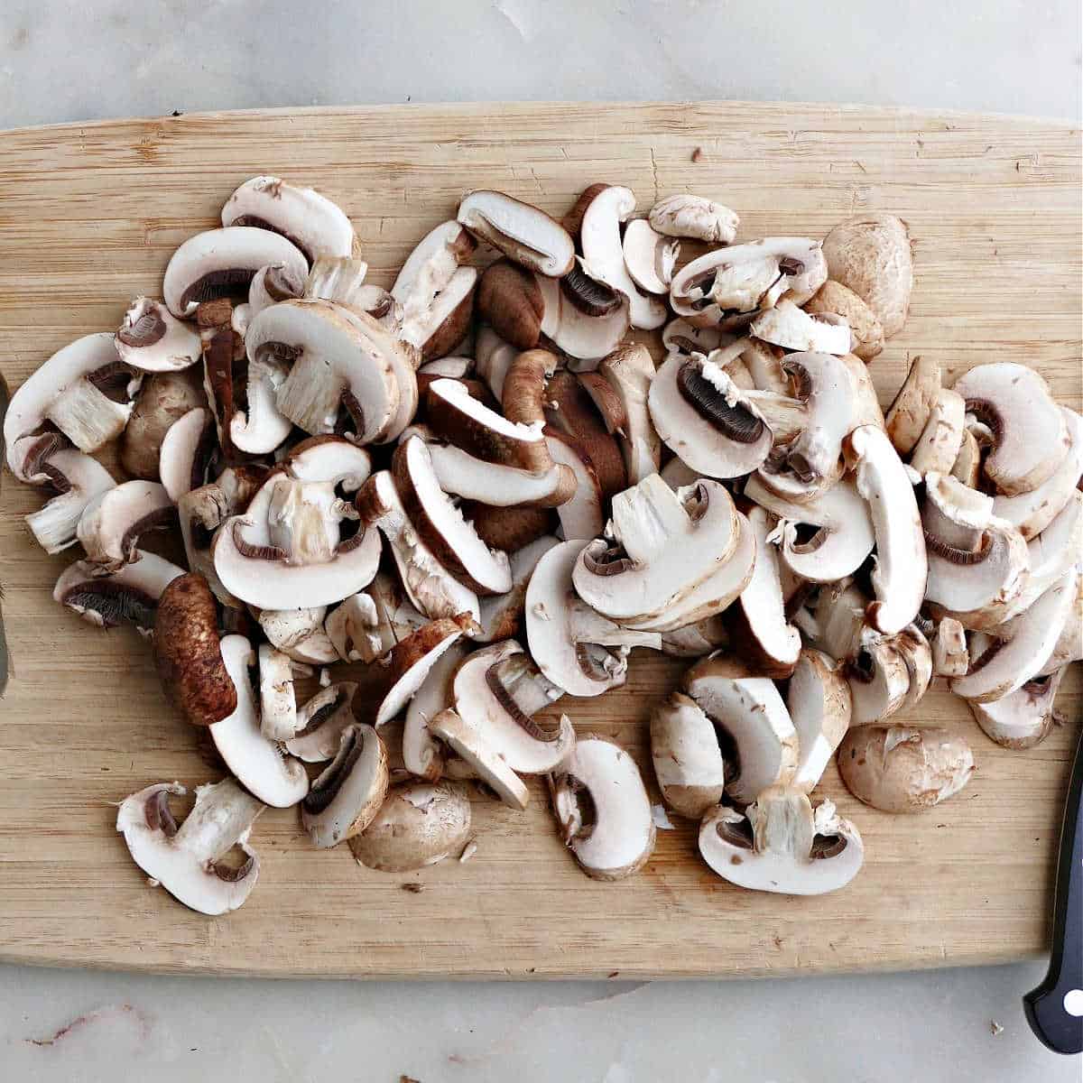 sliced mushrooms on a cutting board with a knife
