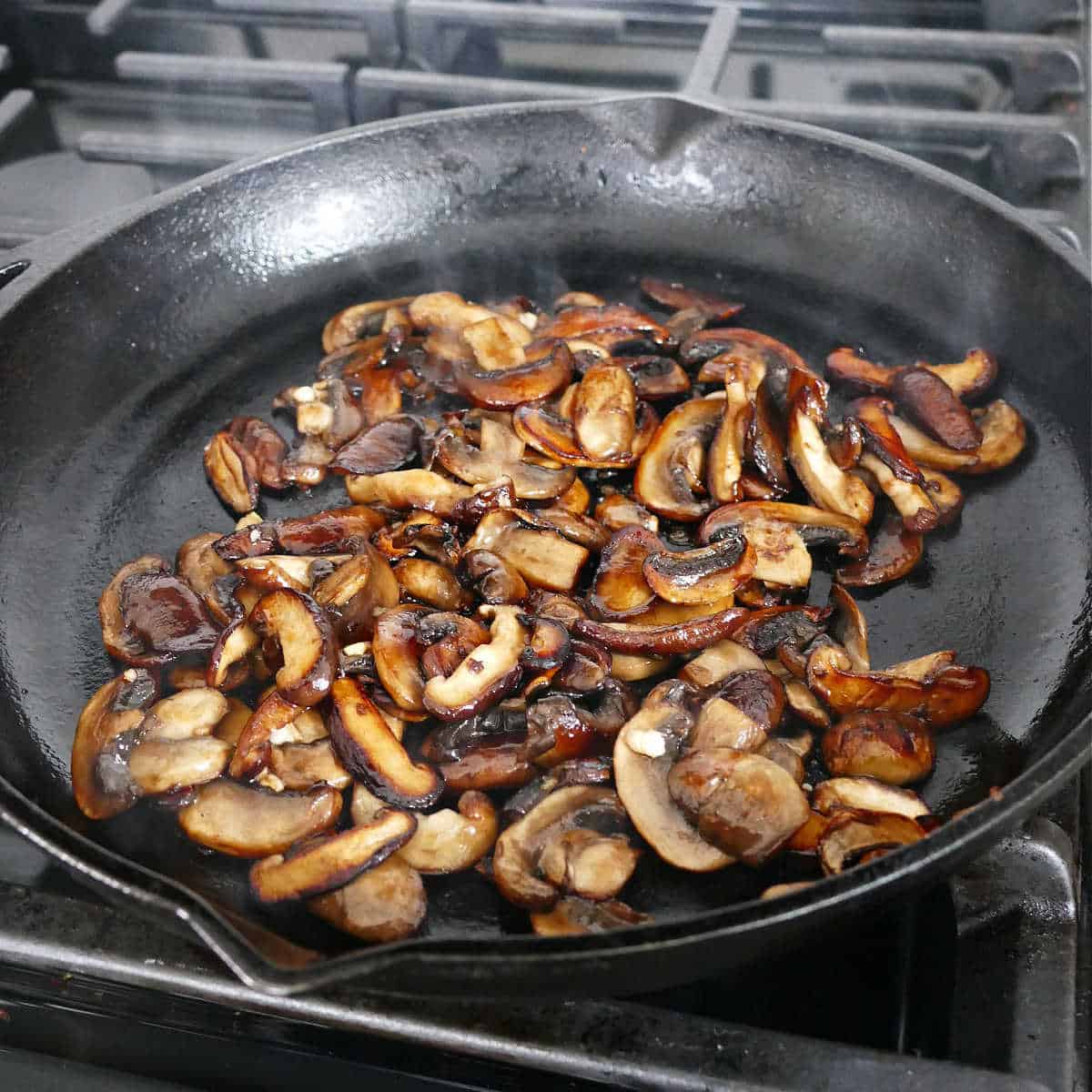 caramelized mushrooms in a skillet before adding vinegar and maple syrup