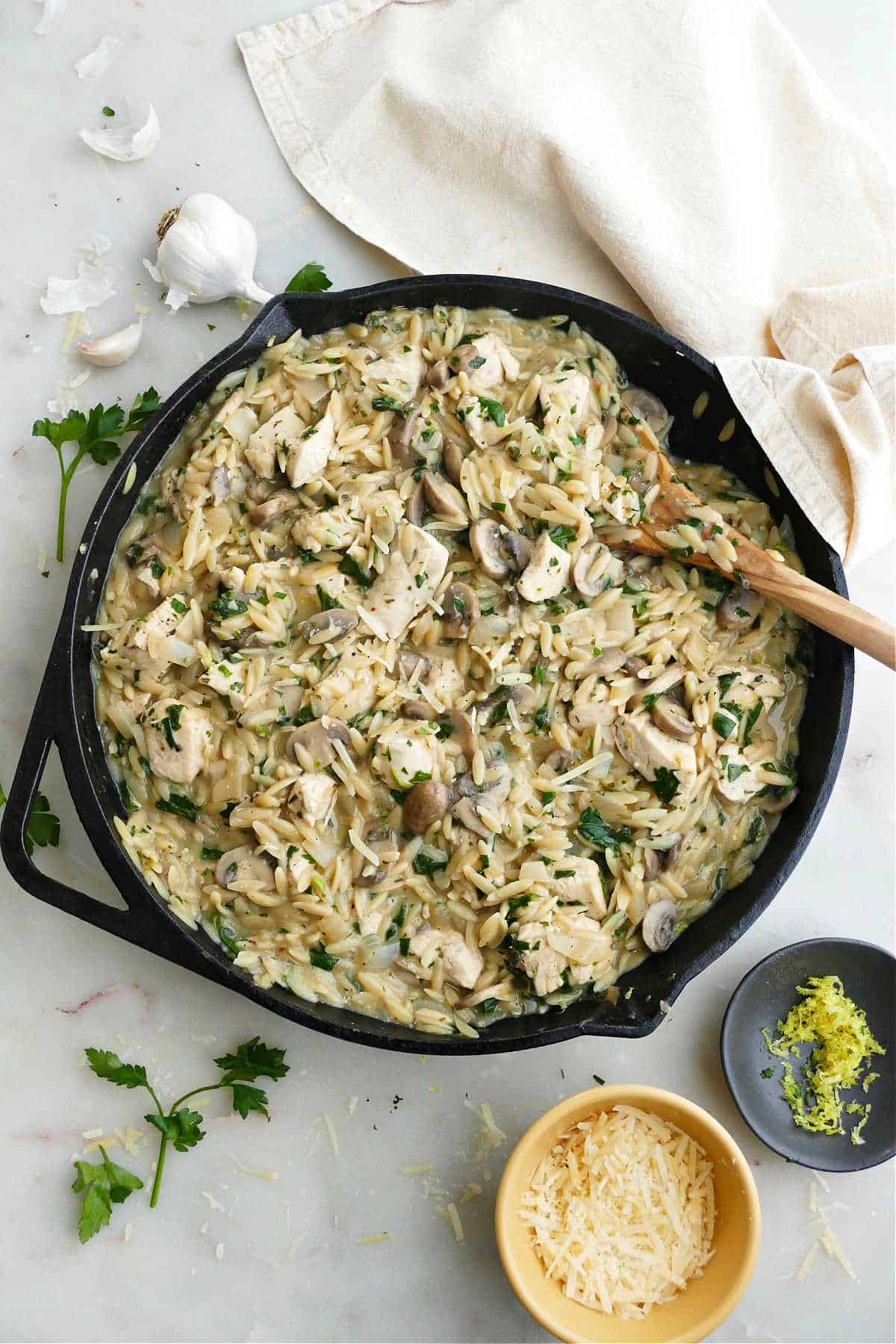 mushroom orzo and chicken dish in a cast iron skillet on a counter