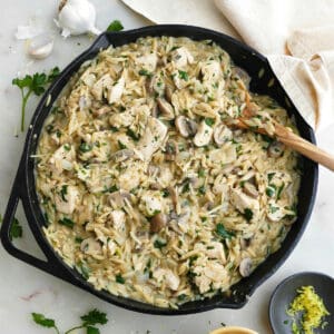 mushroom orzo and chicken dish in a cast iron skillet on a counter
