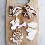 five different types of mushrooms cut up on a cutting board