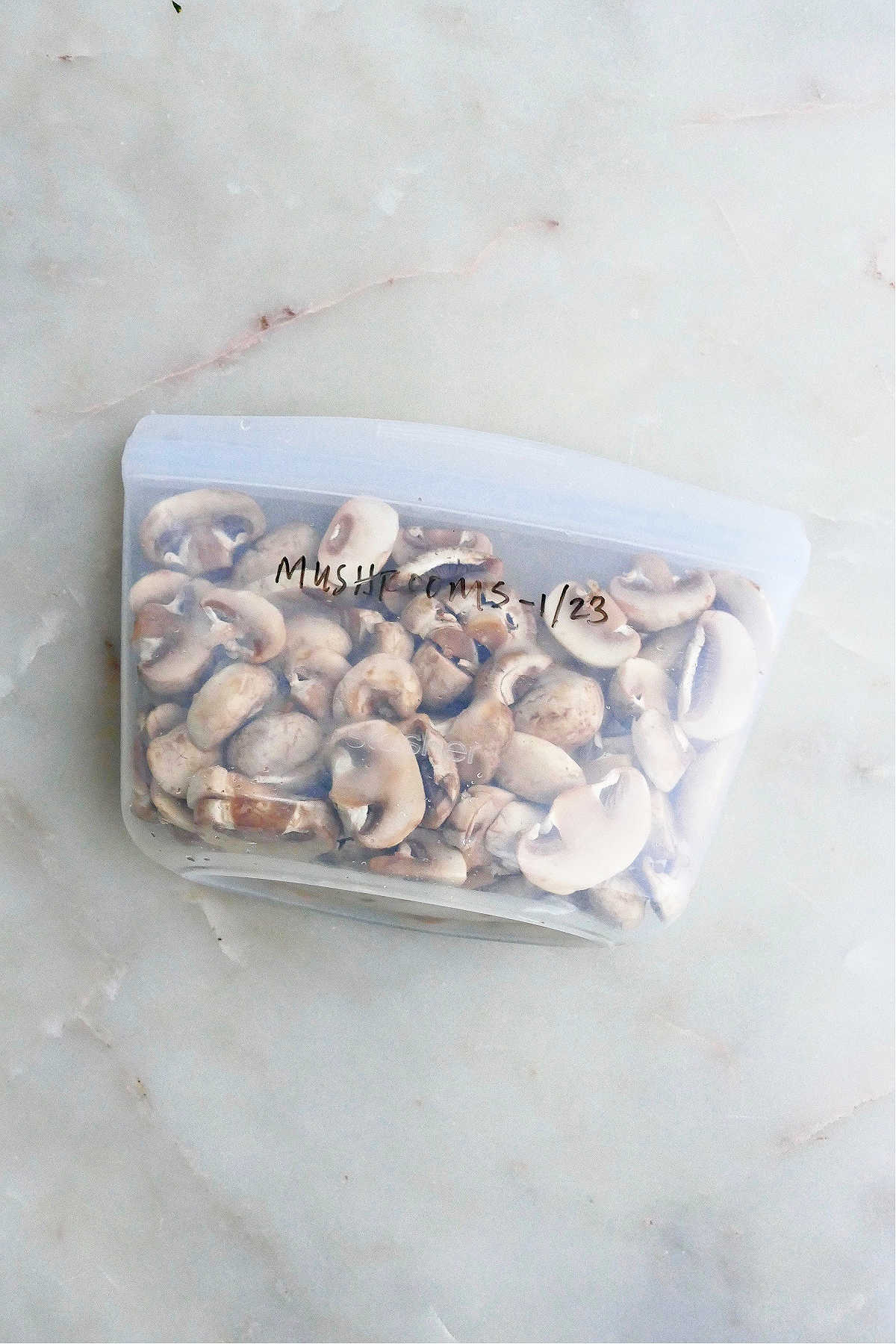 frozen mushrooms in a silicone bag with label on a counter