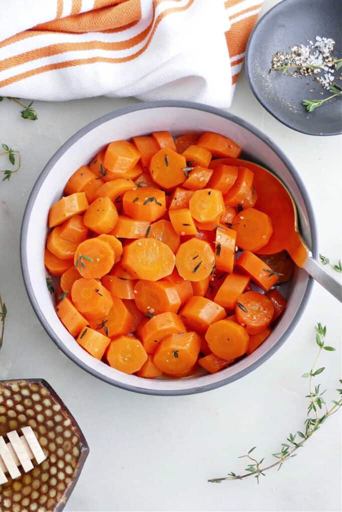 cooked carrots with honey and thyme in a serving bowl