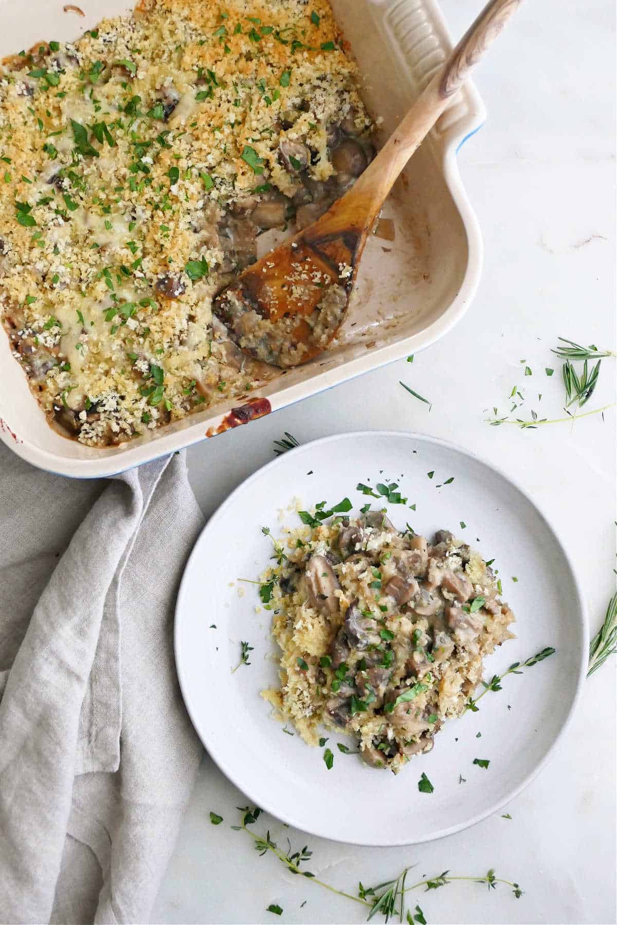 mushroom gratin in a dish next to plate with a serving