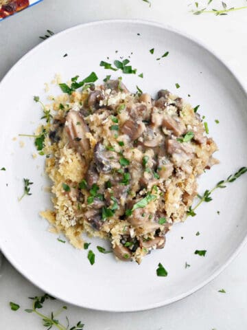 serving of mushroom au gratin on a plate with thyme